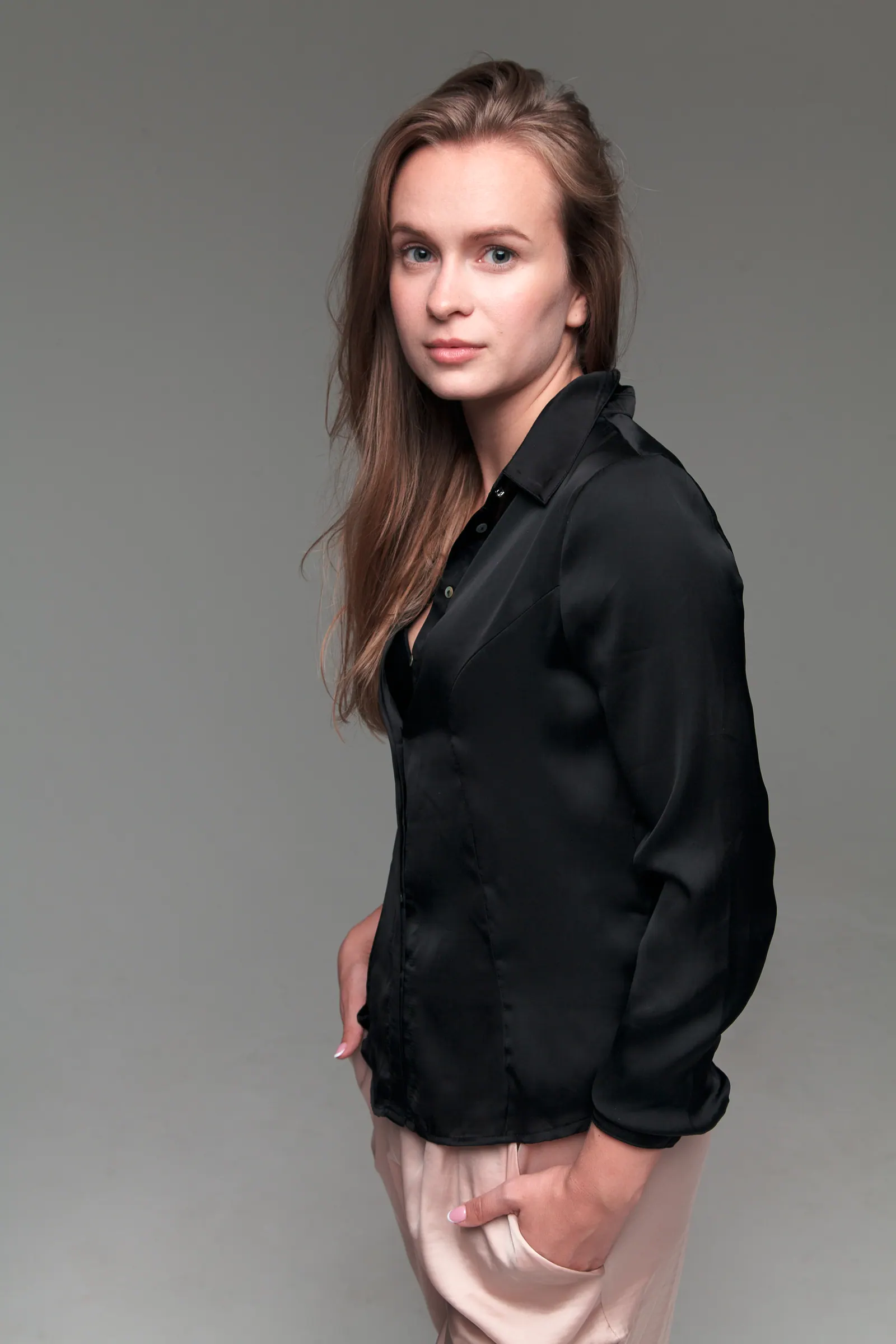 Full-length portrait of Krystyna in a black blouse and satin trousers